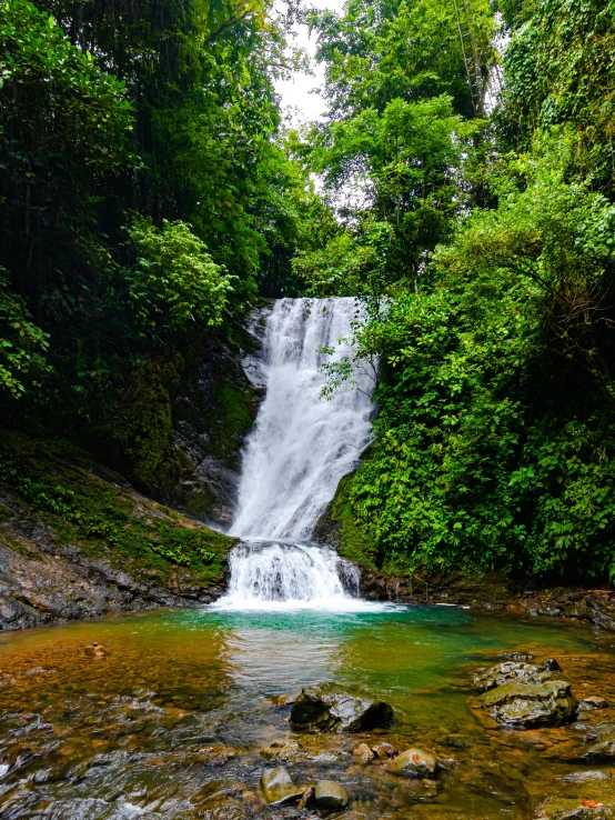 a large waterfall is in the middle of some rocks