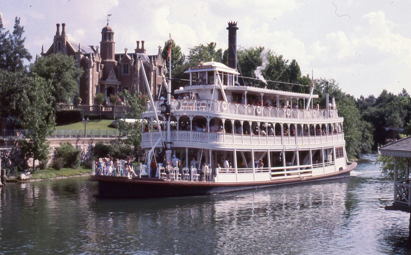 large white boat with people inside it moving on water