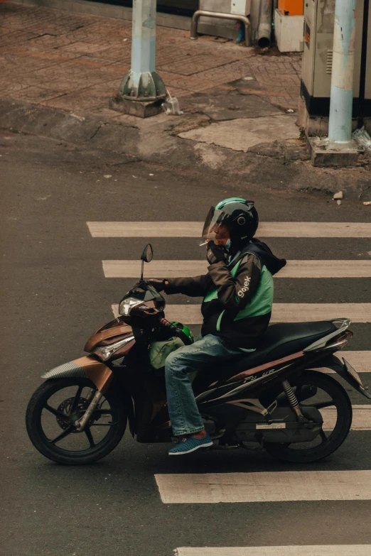 two people riding a motorcycle in the middle of a street