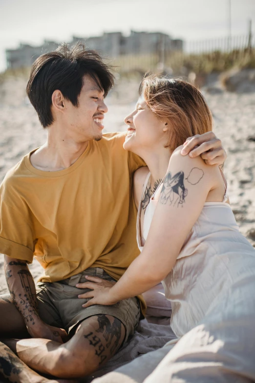 a man with his arm around a woman on the beach