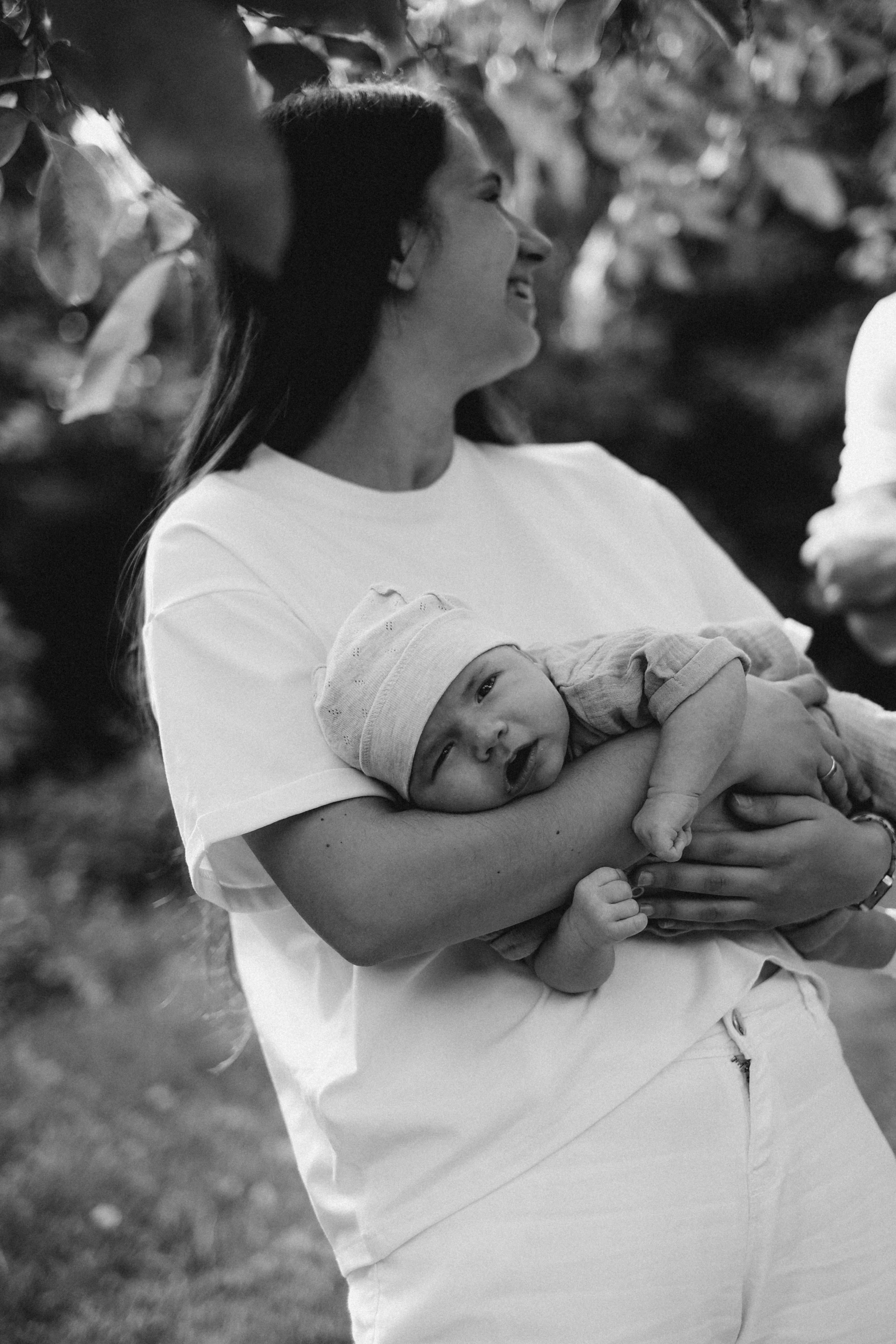 a woman holds her baby outside in the sun