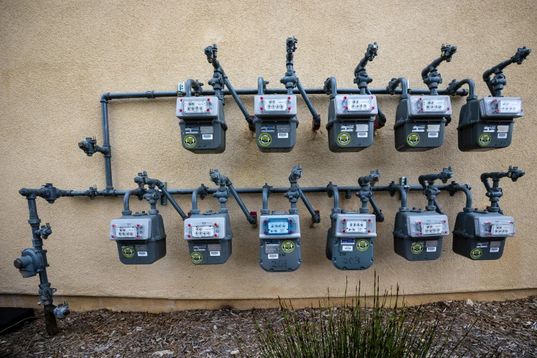 a wall of parking meters on a cement slab