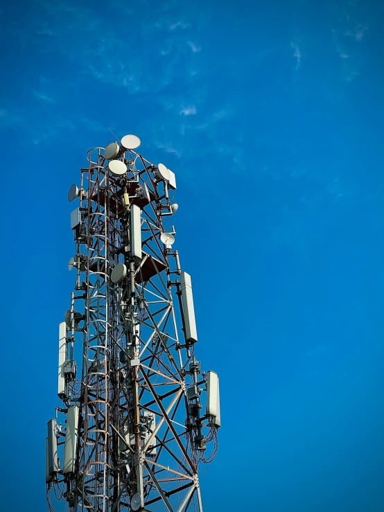 the top of a telephone tower in front of a bright blue sky