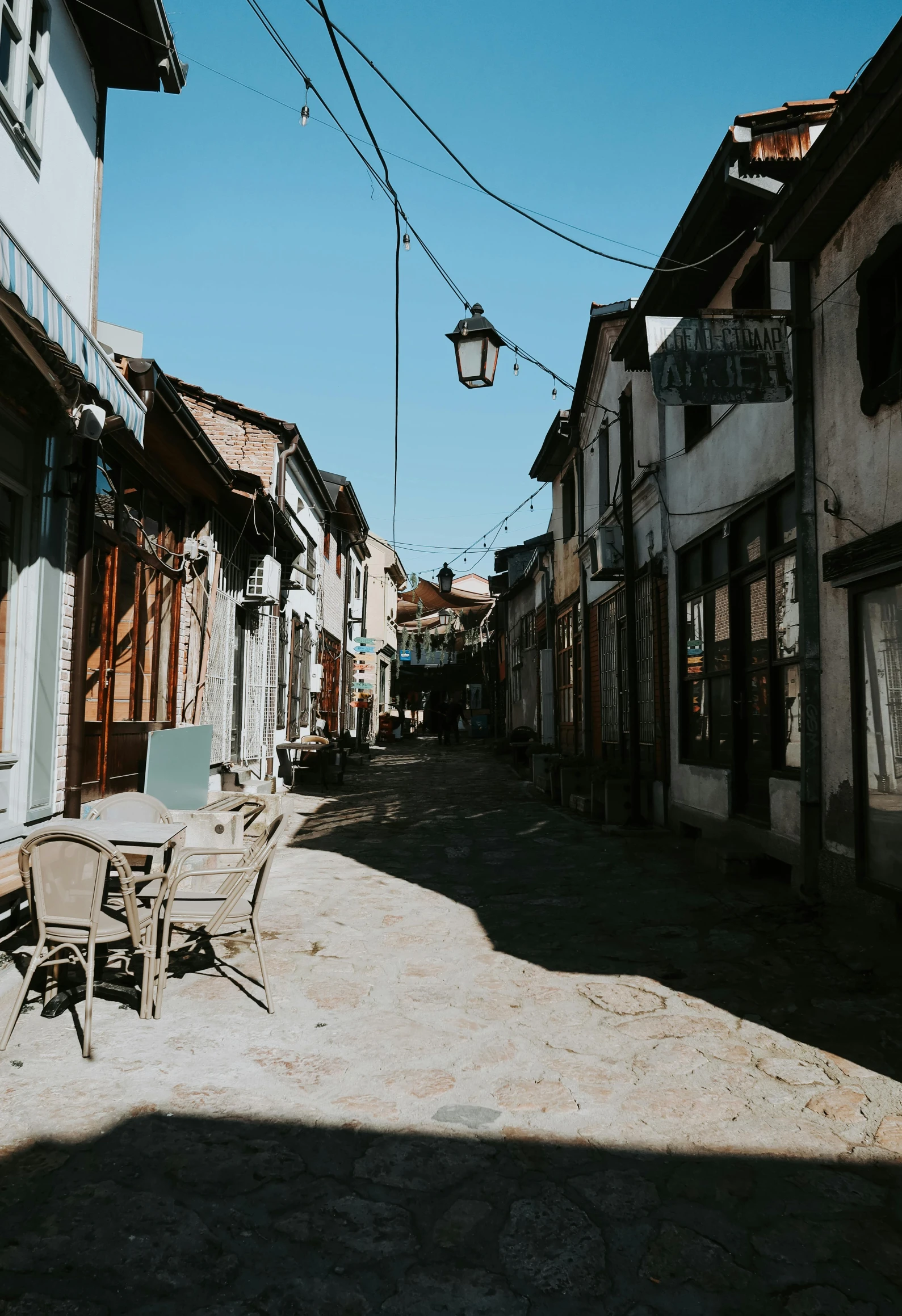 an old cobblestone street has a patio table and chairs