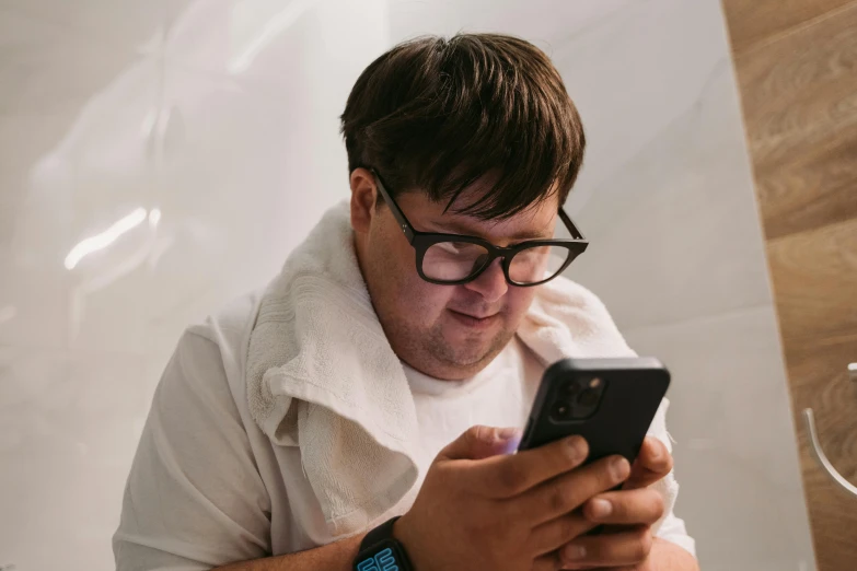 a man in glasses using his cell phone