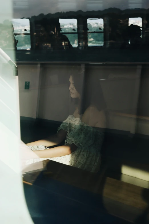 a woman is sitting at the window looking outside