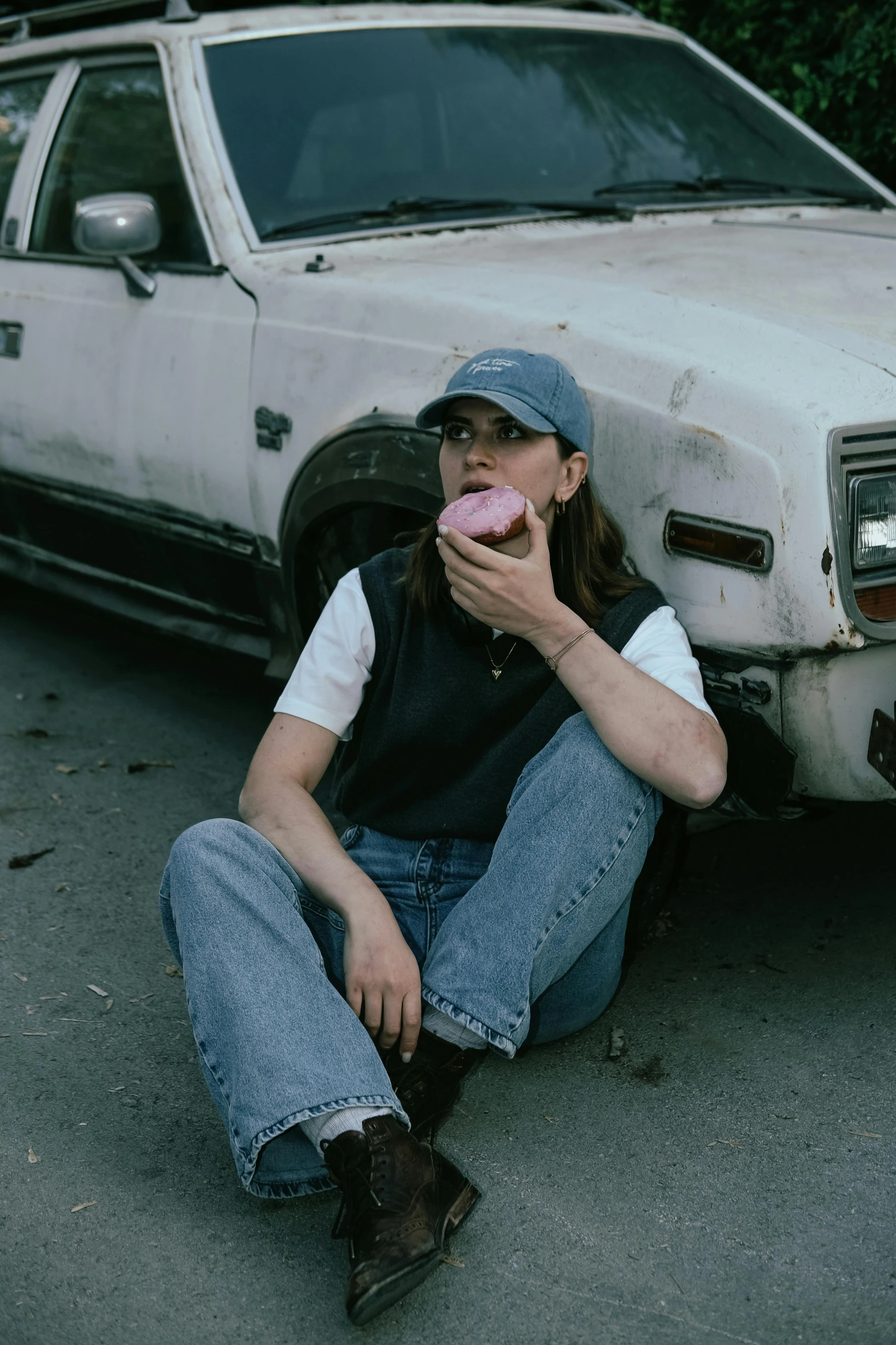 a young woman sitting in front of an abandoned truck