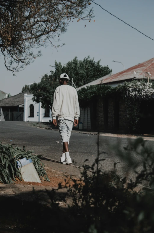 a man walking down the street in the sun