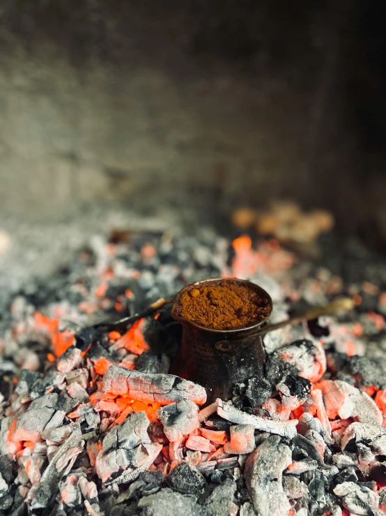 a wooden container with red sand near a fire