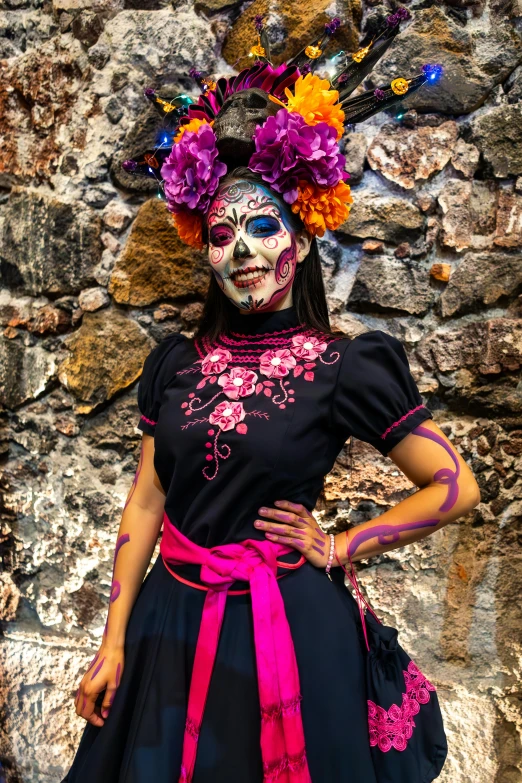 the woman wearing colorful face paint stands in front of a wall