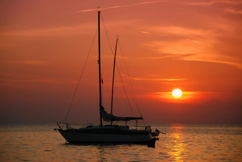 a sunset over a body of water with a boat