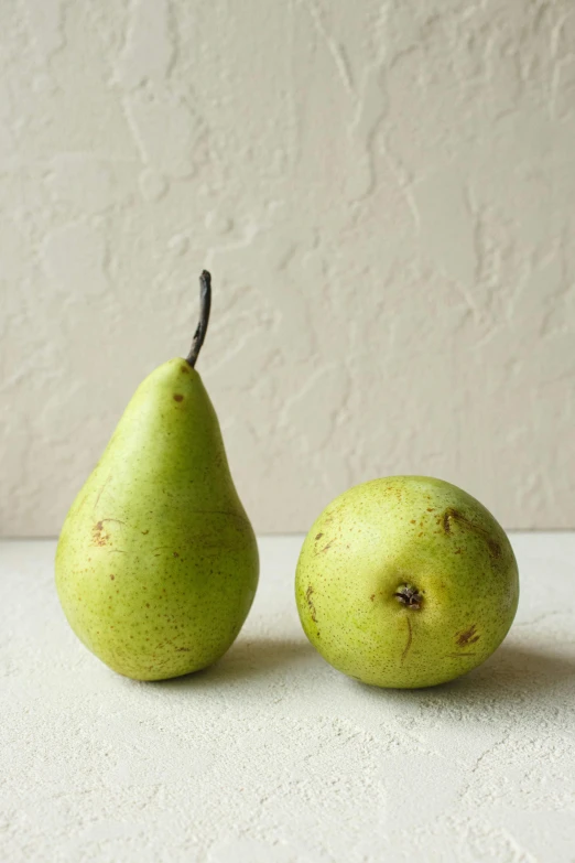 two pears one in green and one yellow with brown marks on their surface