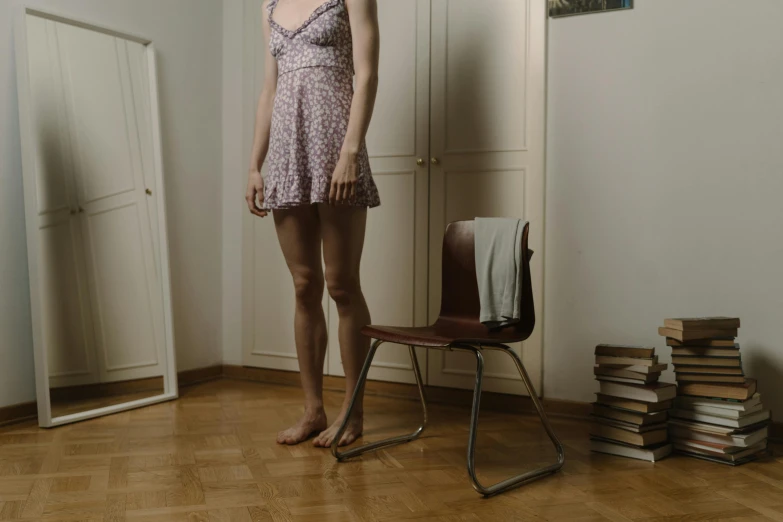 the young woman is standing in the empty room with a chair