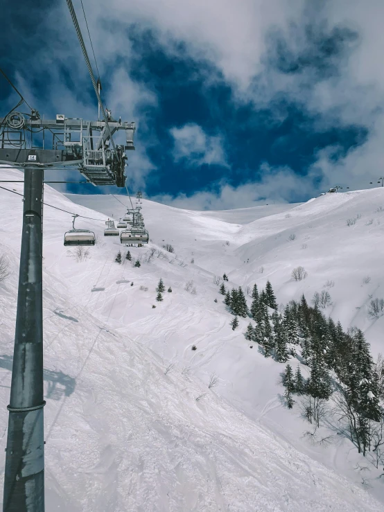 a ski lift above a snowy slope under a blue sky