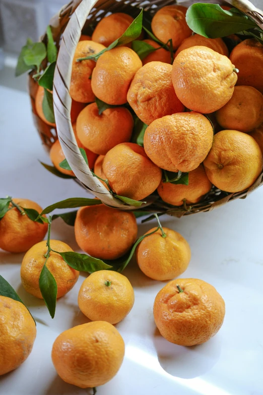 there is a basket filled with tangerines on a table