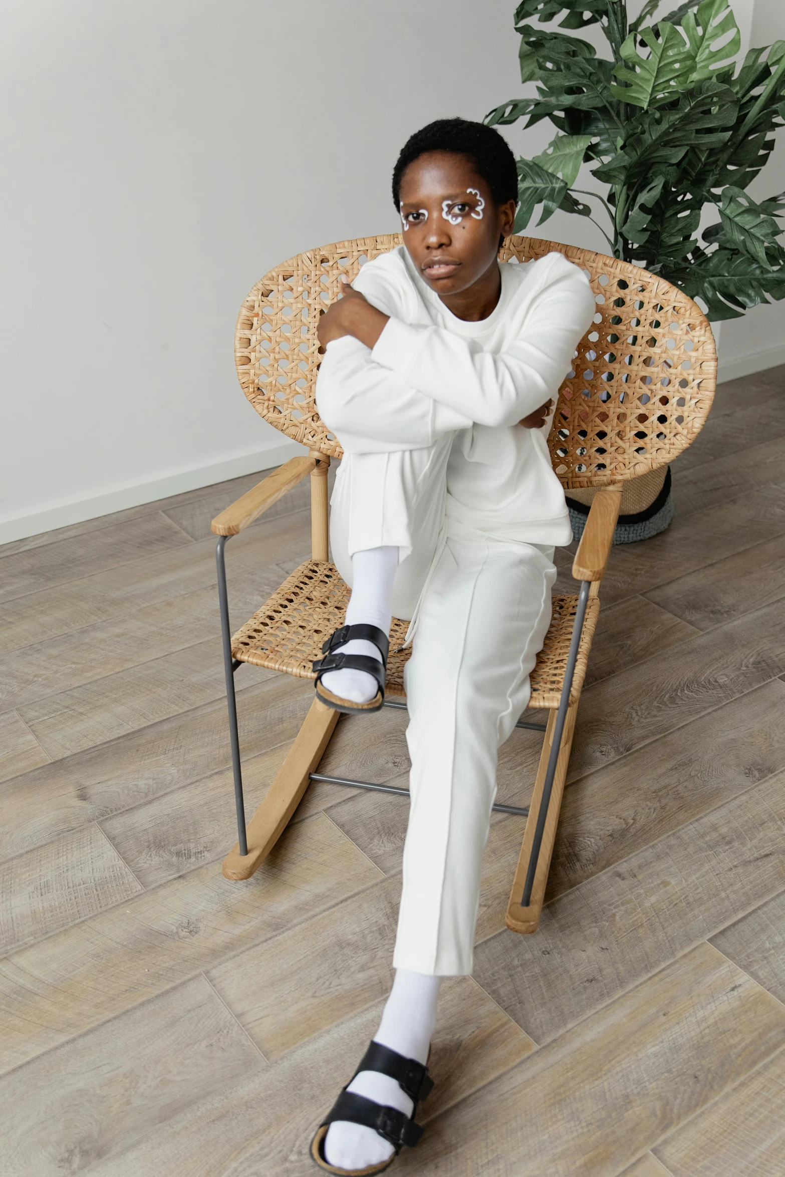 a woman sitting on a chair, with her arms resting on a chair