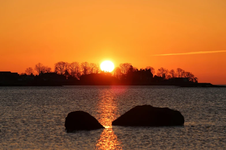 a sunset over the water as seen from the shoreline