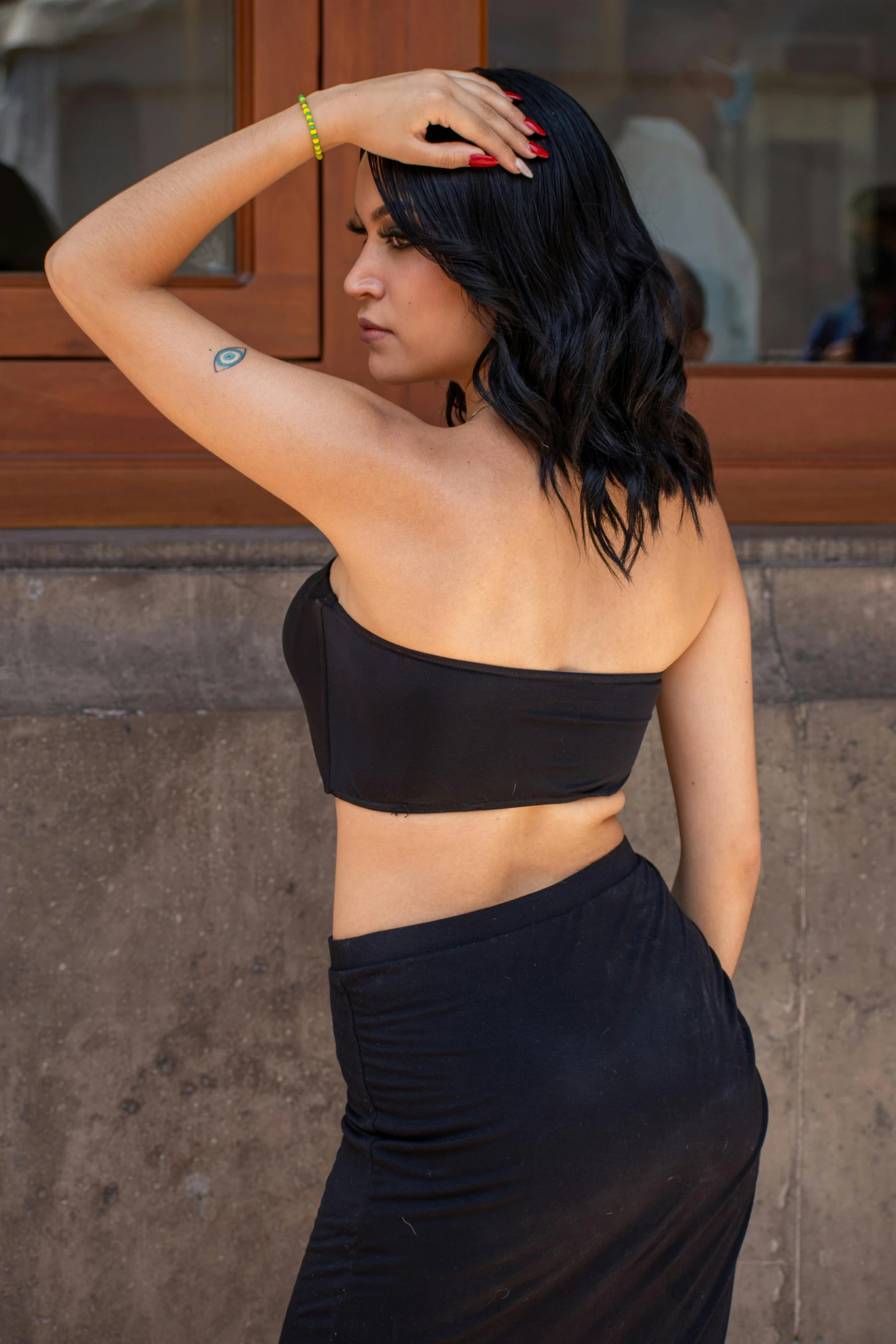 woman in black bikini top standing in front of a building