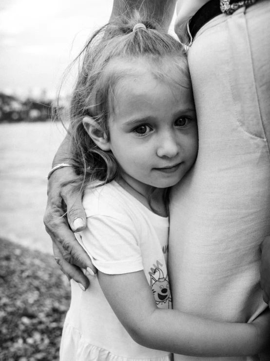 a girl hugs her father as he holds her