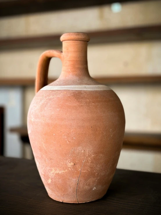 the vase is on the wooden table by the wall