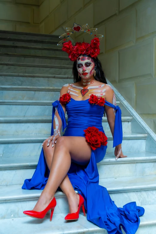 a beautiful woman wearing red flowers sitting on top of a set of stairs