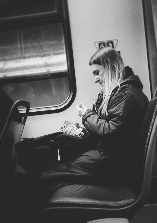 black and white po of a woman sitting on train
