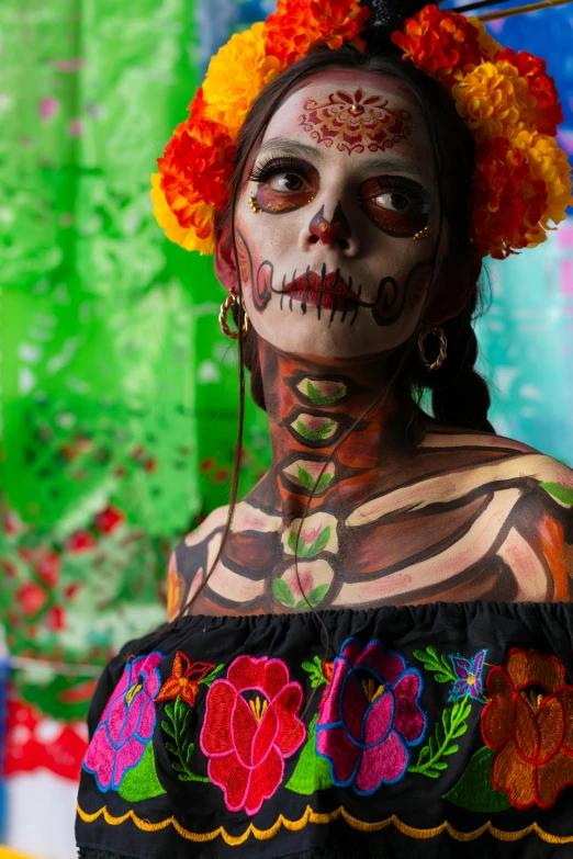 a woman with painted face and body in mexican costume