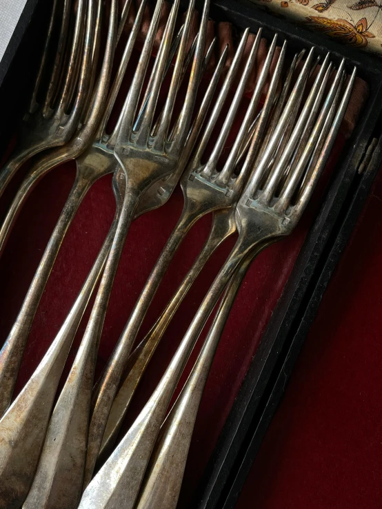 a group of forks sitting inside of a metal box