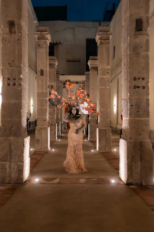 there are tall vases holding flowers inside of an empty building