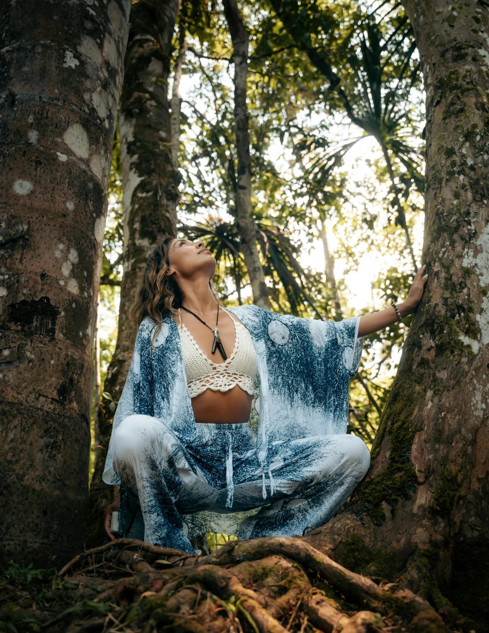 a lady sitting on top of a tree trunk