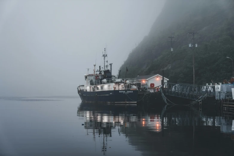 a boat docked at a small pier in the fog