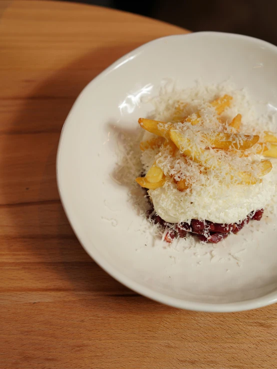 small round dish on a wooden table with white food in it