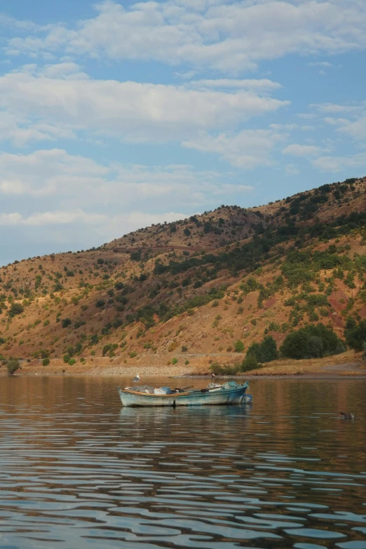 some boats in the water next to a hill