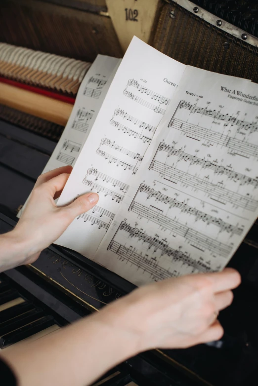 a woman holding an open sheet of musical notation