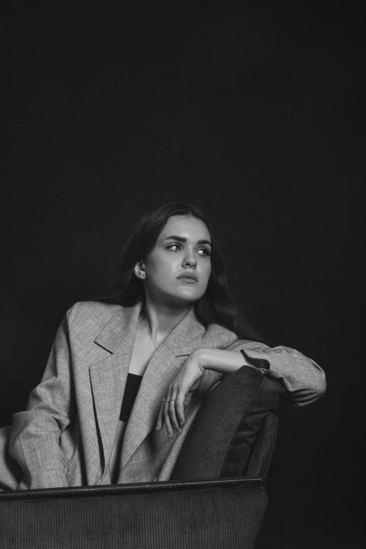 a black and white image of a young man sitting