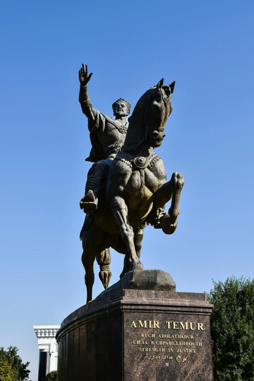 the statue is in front of some green trees