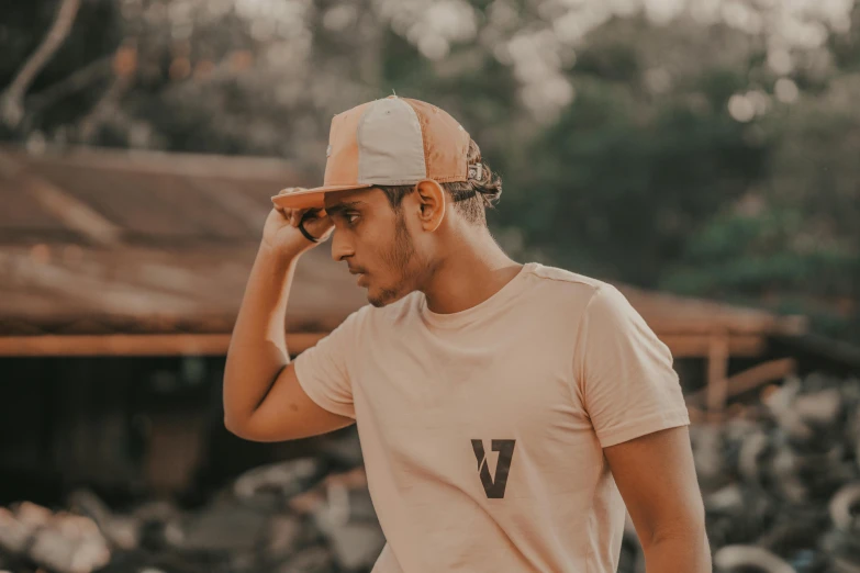 man with white cap standing next to rocks