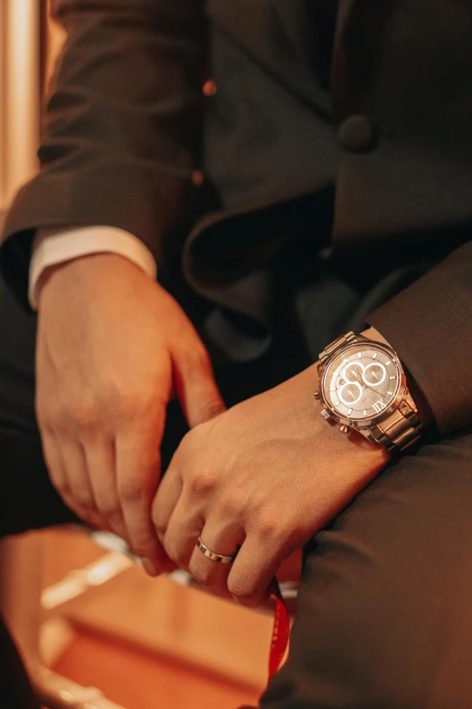 a person wearing a suit and watch sitting down