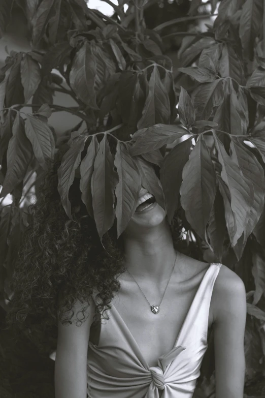 a woman in dress standing next to a tree