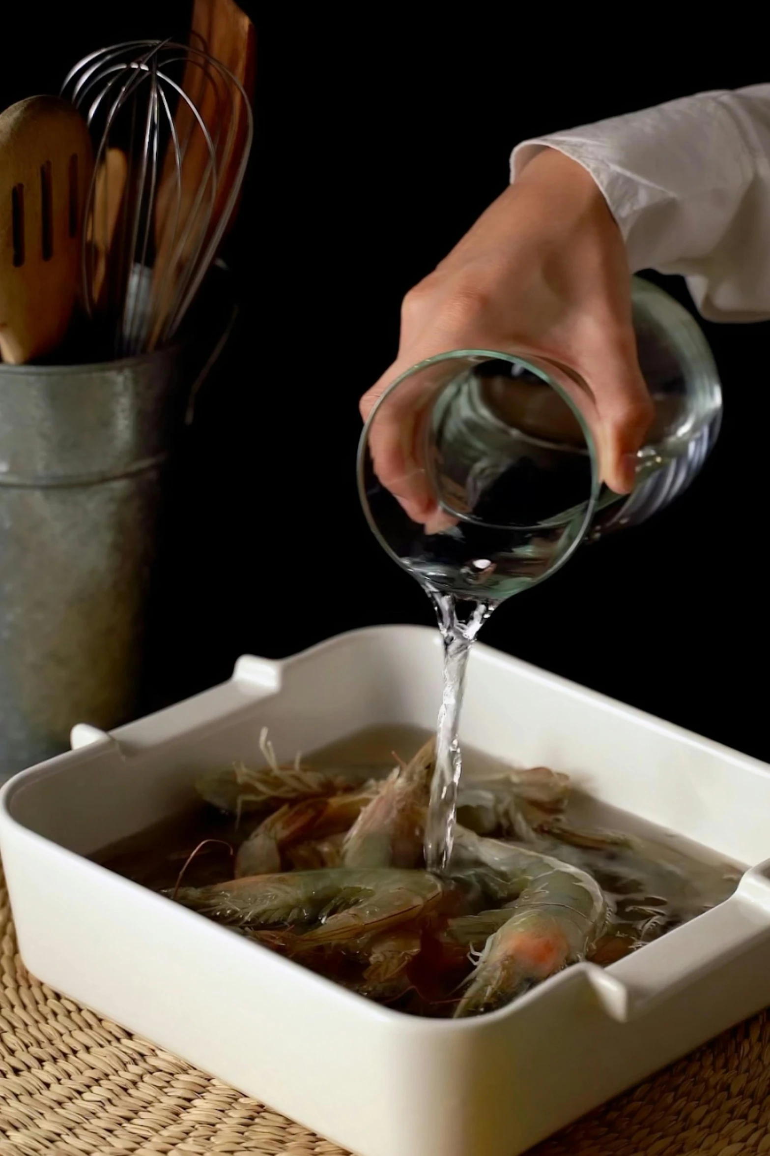 the man is pouring water into the small square container