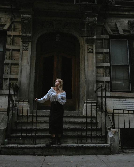 a woman stands outside of a dark house