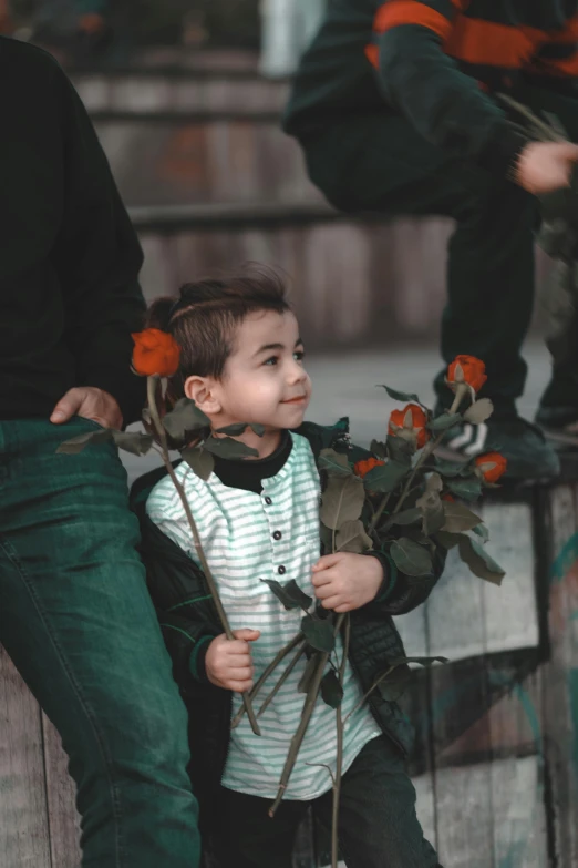 a little boy holding some flowers and holding soing