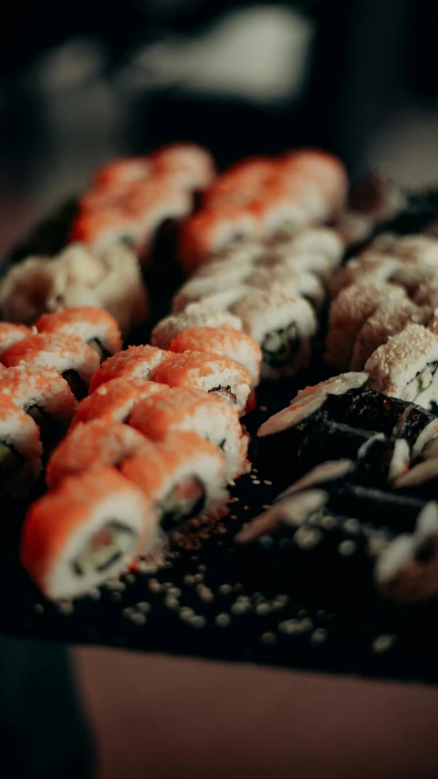 many small sushi are arranged on a tray