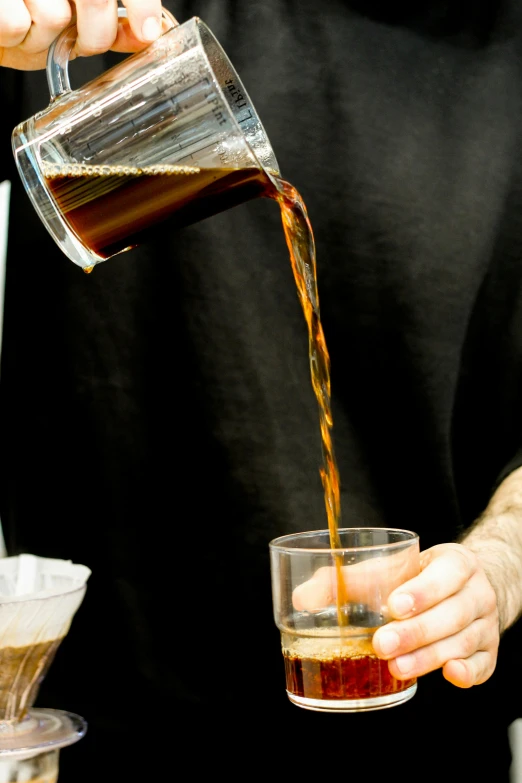 the man is pouring the drink into his glass