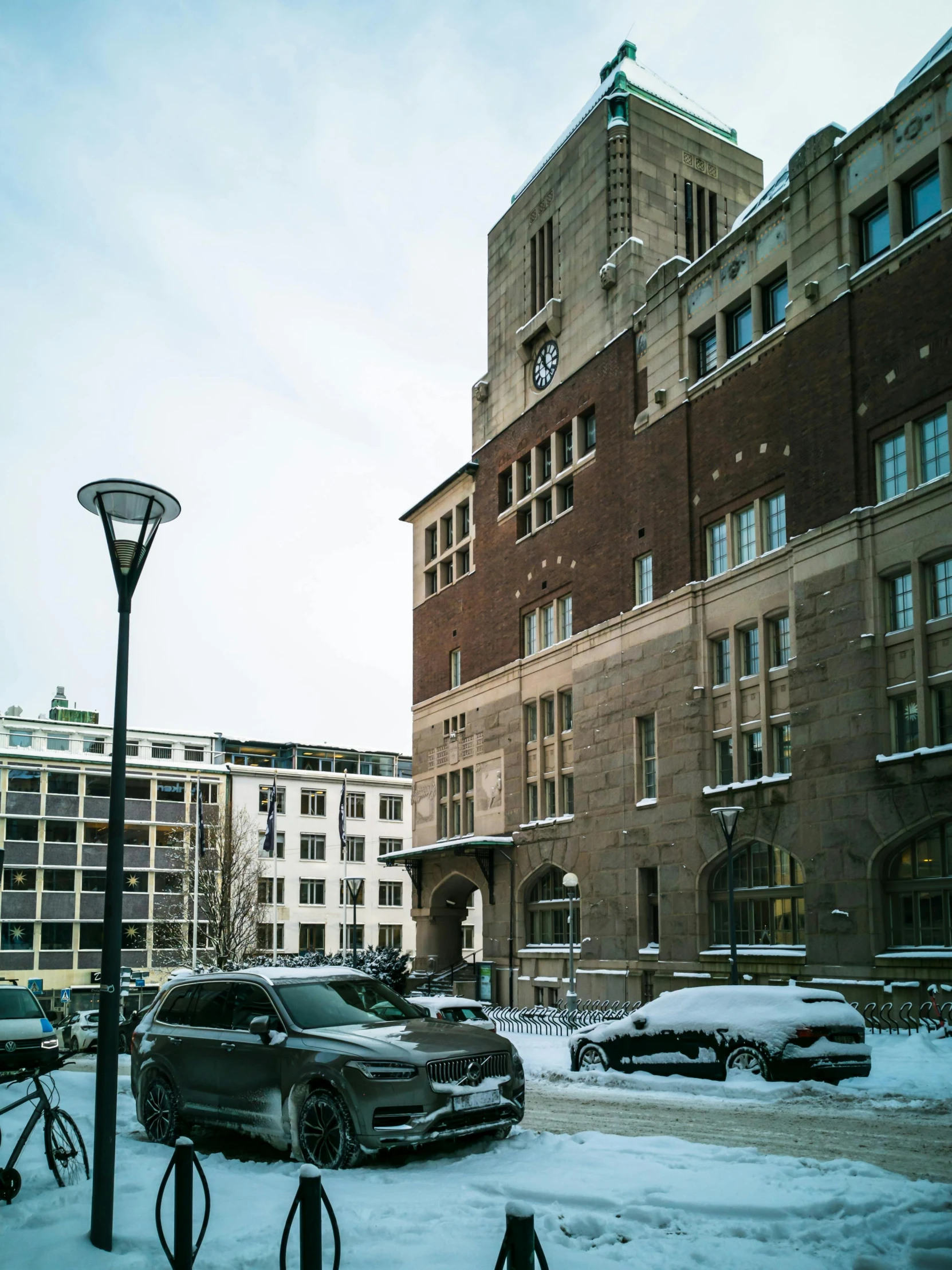 two cars are parked in front of a large building