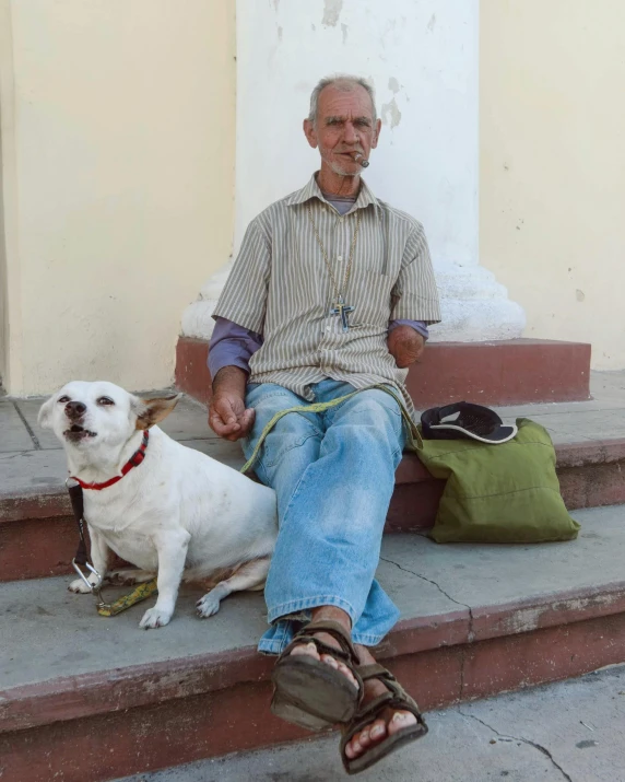 a man is sitting with his dog on the steps