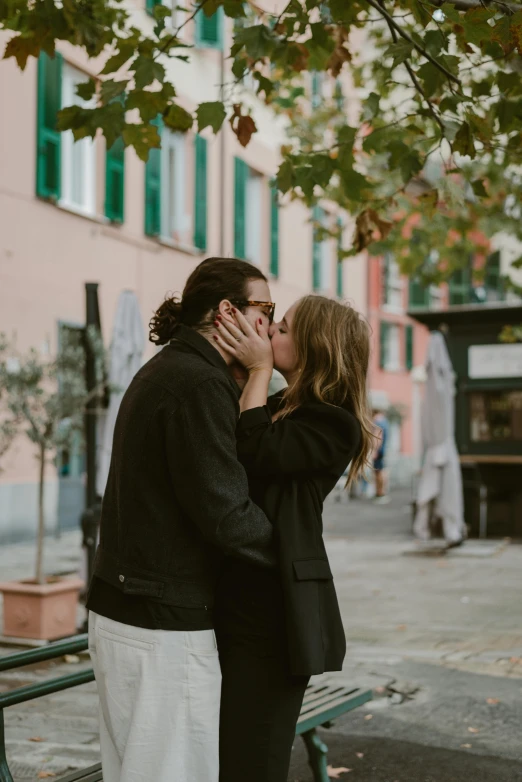 a man and woman kissing on a bench