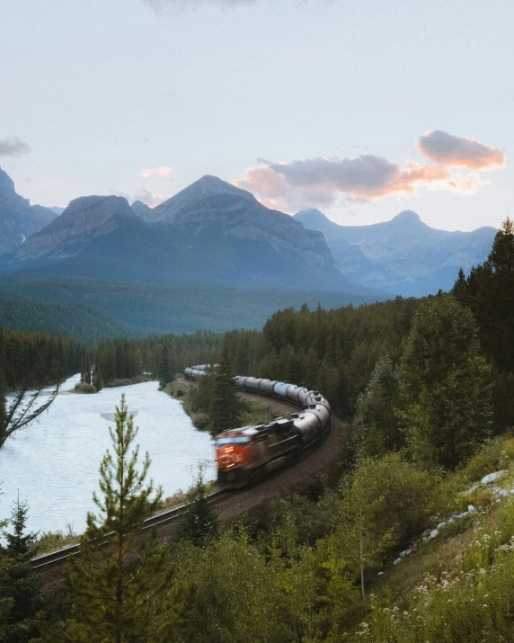 a train is making its way along a winding hill and through the woods