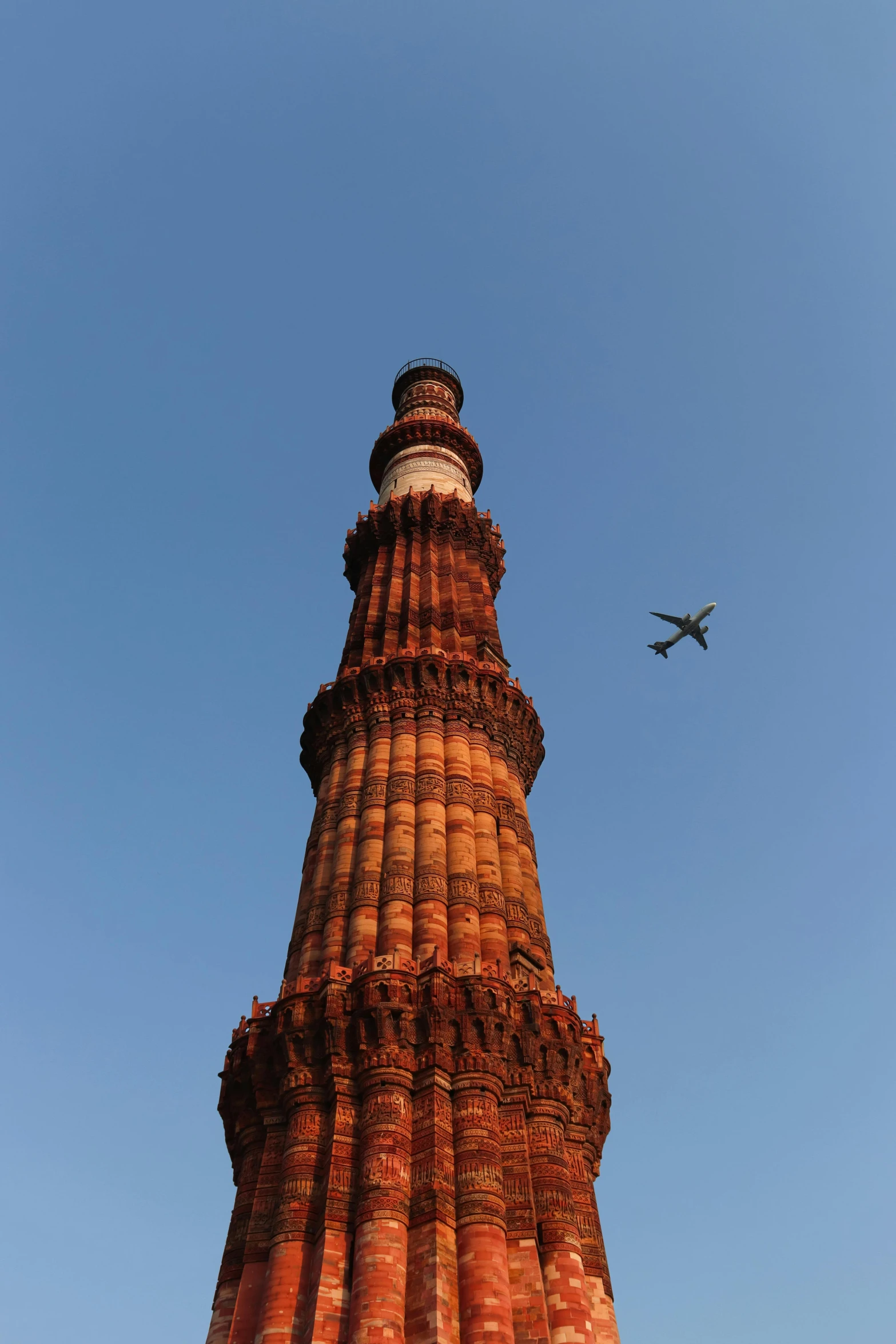 an airplane flying over an orange building in the sky