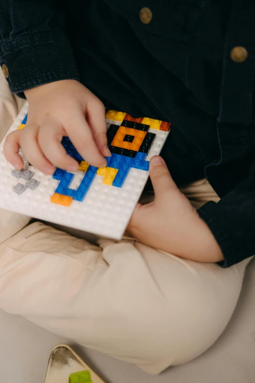 a child with a lego block and a video game controller